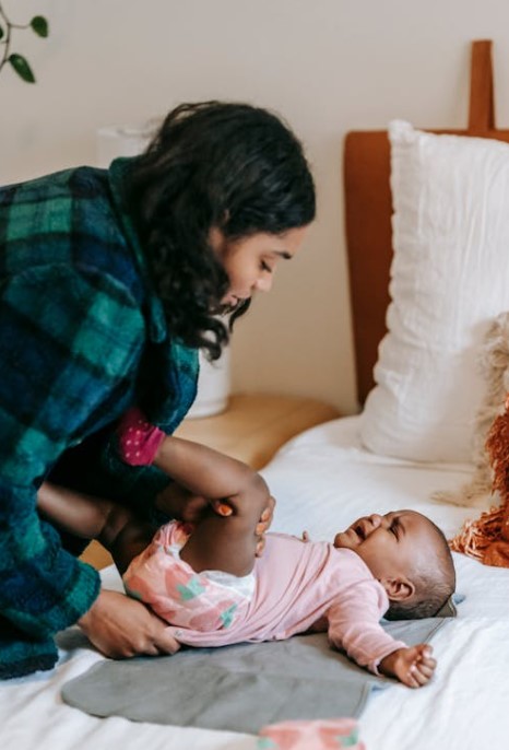 changing newborn diaper in bed